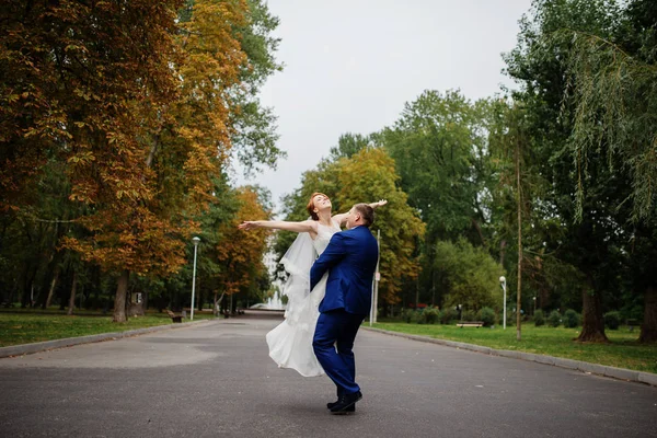 Wedding couple in love at cloudy day, walking on city. Groom hol — Stock Photo, Image