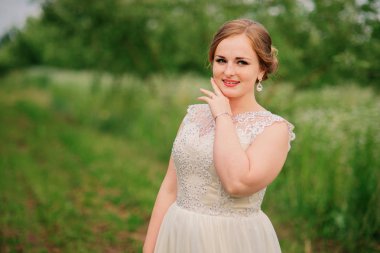 Genç kız bej elbise arka plan bahar gar poz verdi, kilolu