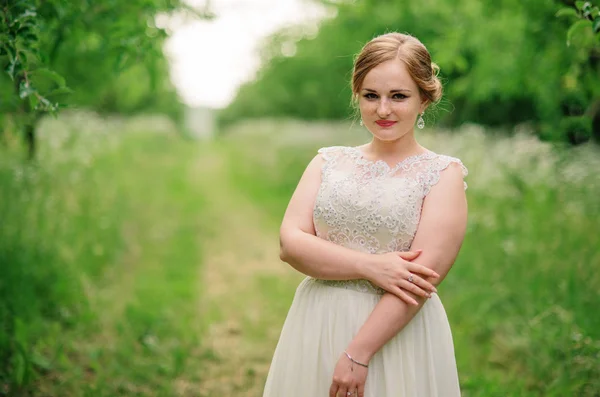 Joven chica con sobrepeso en vestido beige posado fondo primavera gar —  Fotos de Stock