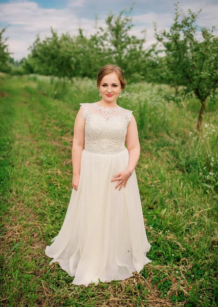 Junge übergewichtige Mädchen bei beige Kleid posiert Hintergrund Frühling gar — Stockfoto