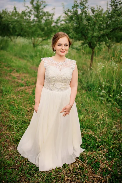 Junge übergewichtige Mädchen bei beige Kleid posiert Hintergrund Frühling gar — Stockfoto