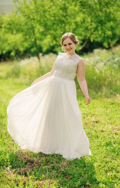 Joven chica con sobrepeso en vestido beige posado fondo primavera gar — Foto de Stock