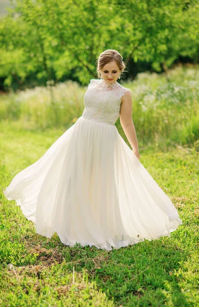 Joven chica con sobrepeso en vestido beige posado fondo primavera gar — Foto de Stock