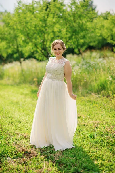 Joven chica con sobrepeso en vestido beige posado fondo primavera gar —  Fotos de Stock