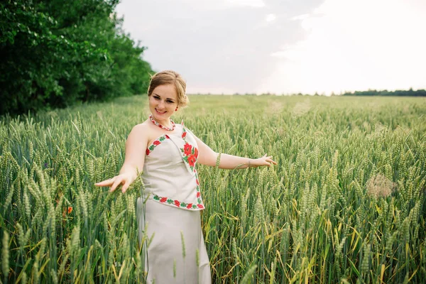 Молодая девушка в украинской национальной одежде позировала на венчальном поле . — стоковое фото