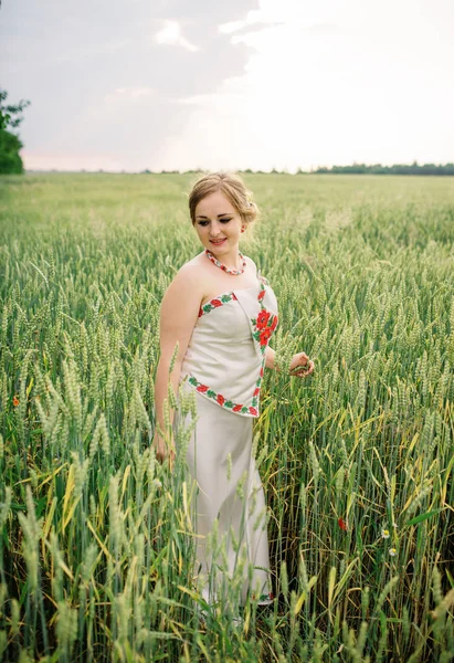 Chica joven en el vestido nacional ucraniano posó en el campo de la corona . —  Fotos de Stock