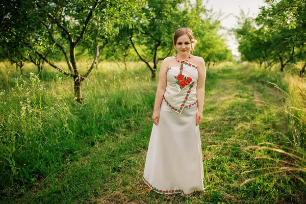 Ukrayna Ulusal elbise genç kıza bahar bahçe poz verdi.. — Stok fotoğraf