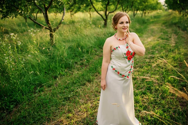Ukrayna Ulusal elbise genç kıza bahar bahçe poz verdi.. — Stok fotoğraf