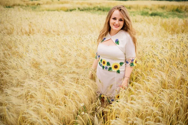 Chica joven en el vestido nacional ucraniano posó en el campo de la corona . —  Fotos de Stock