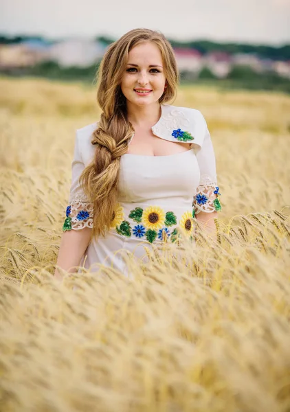 Chica joven en el vestido nacional ucraniano posó en el campo de la corona . —  Fotos de Stock