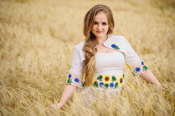 Chica joven en el vestido nacional ucraniano posó en el campo de la corona . —  Fotos de Stock