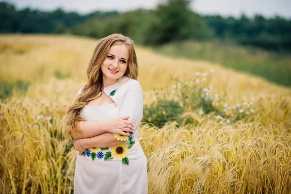 Chica joven en el vestido nacional ucraniano posó en el campo de la corona . —  Fotos de Stock