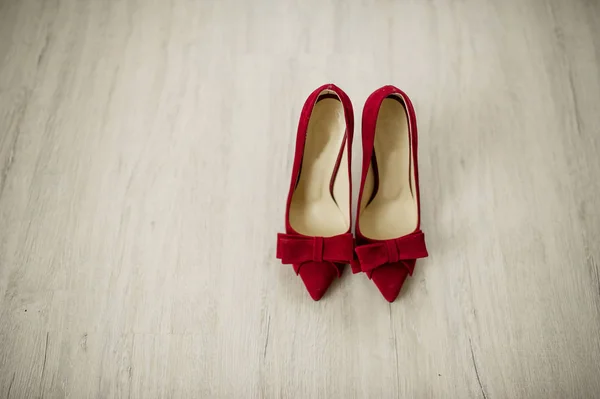 木製の背景に赤いベルベットの花嫁の靴. — ストック写真