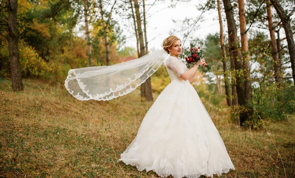 Novia rubia con ramo de bodas y maquillaje brillante en otoño p — Foto de Stock