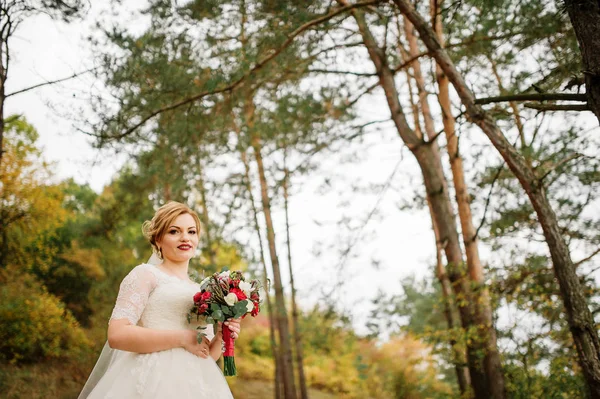 Blonde bride with wedding bouquet and bright make up at autumn p — Stock Photo, Image