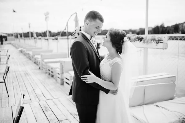 Bájos esküvő házaspár átölelve a dock a mólón. — Stock Fotó