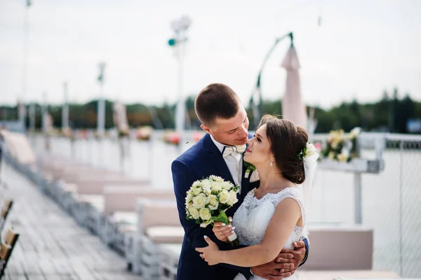 Charmiga bröllop par kramas på piren i dockan. — Stockfoto