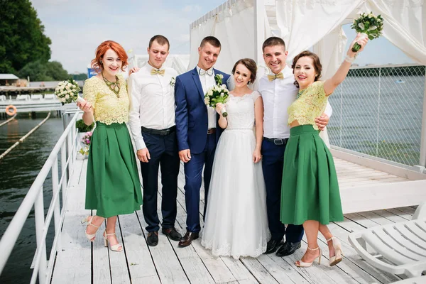 Pareja de bodas con damas de honor y los mejores hombres en el muelle . — Foto de Stock