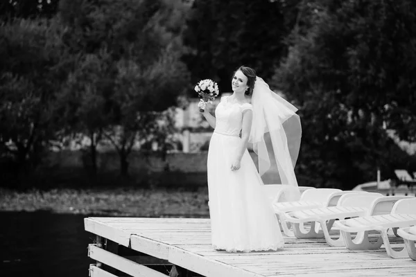 Портрет милой брюнетки невесты со свадебным букетом на руках — стоковое фото