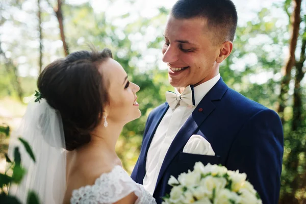 Liebendes junges Hochzeitspaar verliebt im sonnigen Wald. — Stockfoto