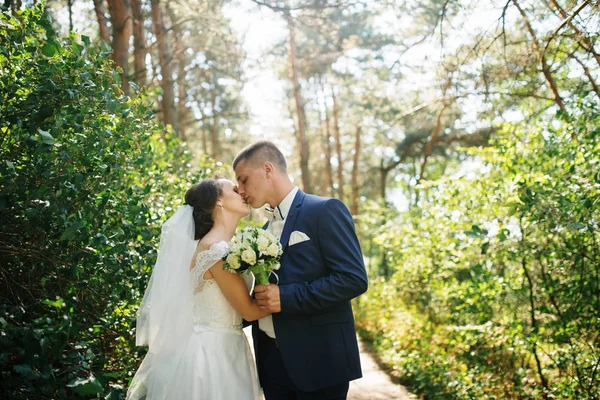 Liefdevolle jonge bruidspaar in liefde op het zonnige bos. — Stockfoto