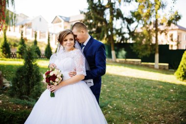 Düğün çifti güneşli sonbahar günü sarılma aşık.