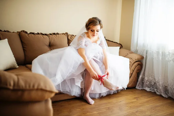 Невеста носит красную подвязку на ноге в день свадьбы . — стоковое фото