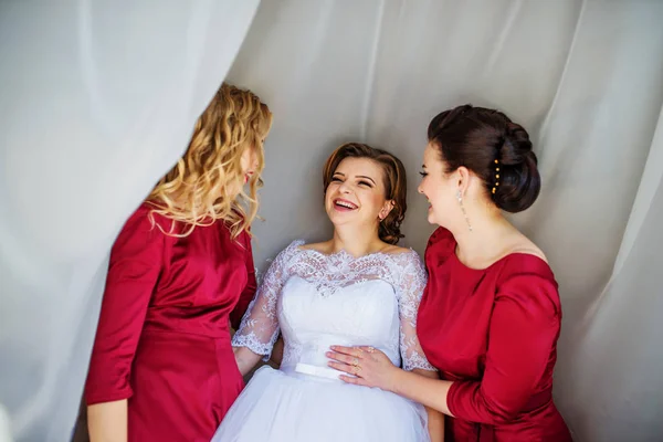 Linda novia rubia con damas de honor posadas en las cortinas en la boda —  Fotos de Stock