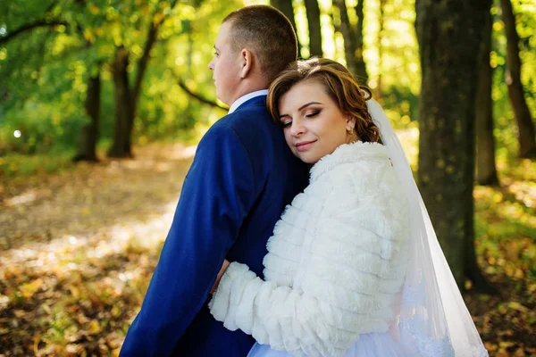 Amorosa pareja de boda abrazándose en el bosque de otoño con licencia amarilla — Foto de Stock