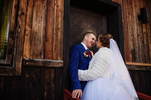 Весільна пара проти старого дерев'яного будинку з червоним листям на його . — стокове фото