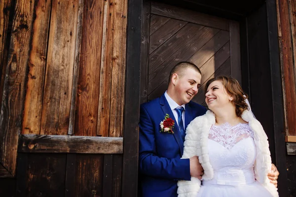 Couple de mariage contre vieille maison en bois avec des feuilles rouges sur son . — Photo