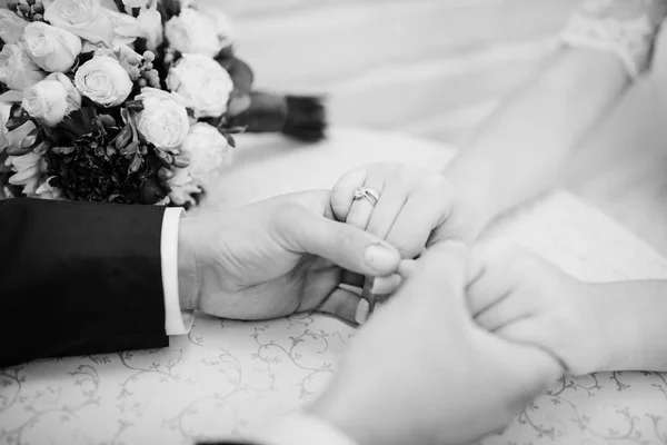 Brides mains aux mains du marié contre le bouquet de mariage. Noir an — Photo