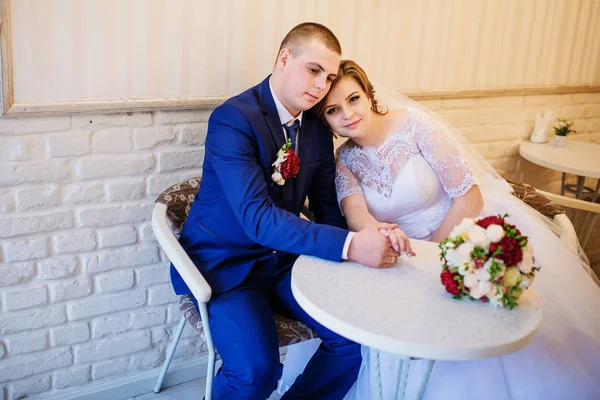 Casamento casal sentado a uma mesa em um café e de mãos dadas . — Fotografia de Stock