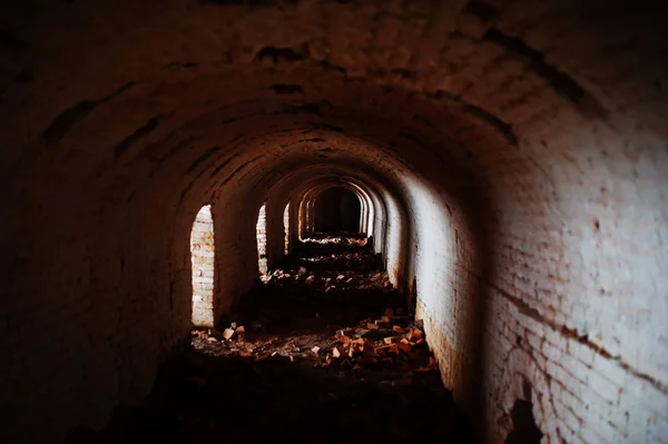 Gruseliger Ziegelbogentunnel bei Dunkelheit und etwas Licht. — Stockfoto