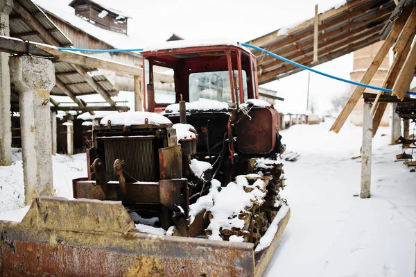 Rusty viejo tractor soviético cubierto de nieve . — Foto de Stock