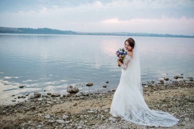 Menekşe düğün buket Nehri'nin beach yakınındaki ile esmer gelin bir