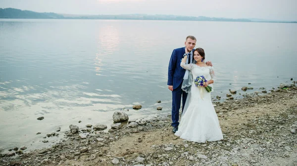 Νεόνυμφους με αγάπη κοντά στον ποταμό ηλιοβασίλεμα στο φοβερό γάμο τους — Φωτογραφία Αρχείου