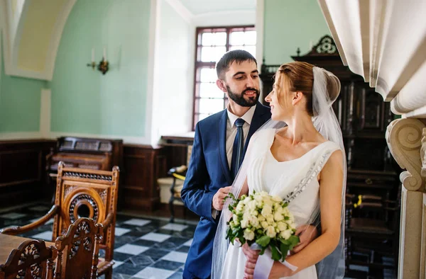 Casal de casamento feliz e adorável na sala do museu antigo com grande — Fotografia de Stock