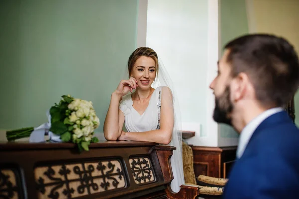 Groom tocar piano para sua noiva sorridente no dia do casamento . — Fotografia de Stock