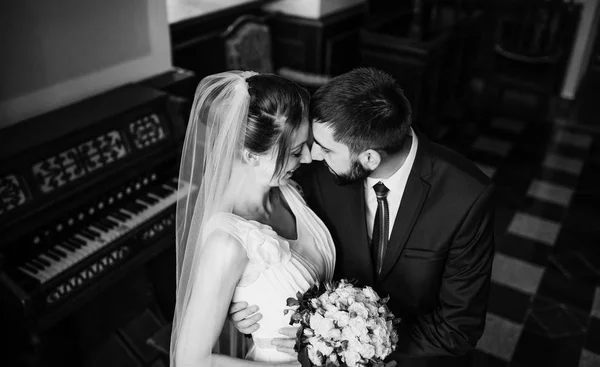 Casal de casamento adorável abraçando na antiga sala antiga perto da janela . — Fotografia de Stock