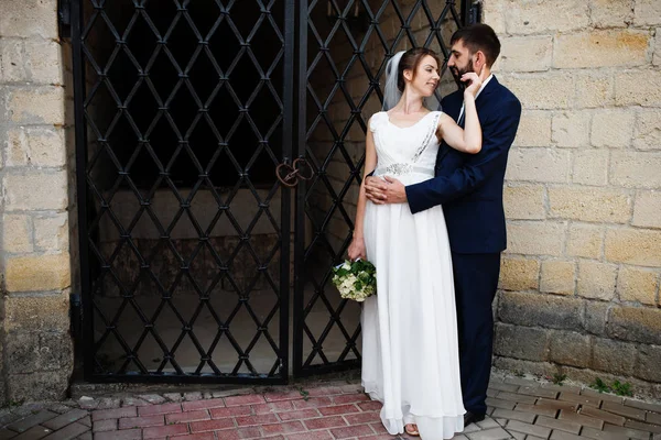 Couple de mariage près de vieilles portes en fer forgé . — Photo