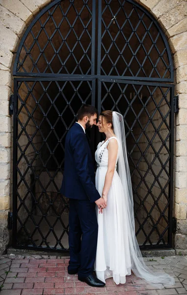 Pareja de boda cerca de viejas puertas de hierro forjado . —  Fotos de Stock