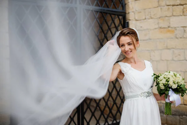 古い錬鉄のゲートの近くの長いベールを持つ花嫁. — ストック写真