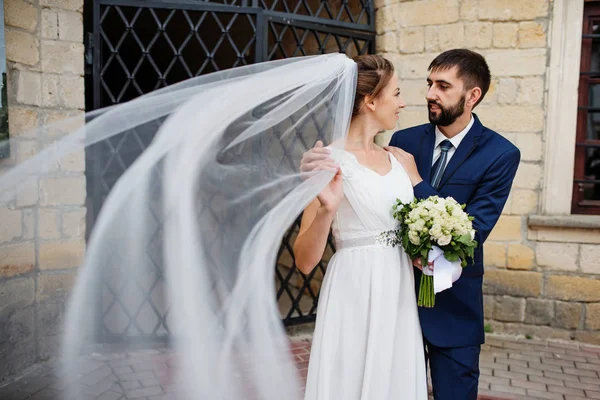 Wedding couple near old wrought iron gates. — Stock Photo, Image