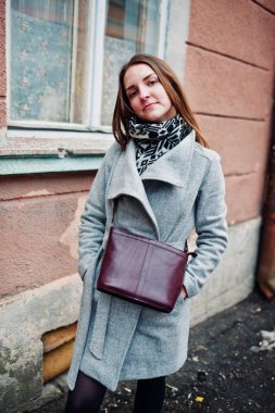 Genç kız deri çanta ile gri paltolu omzuna model.
