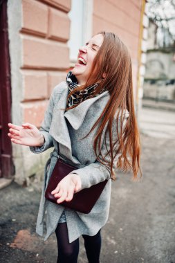 Genç kız deri çanta ile gri paltolu omzuna model.