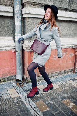 Genç kız bir gri ceket ve deri handb ile siyah şapka modeli