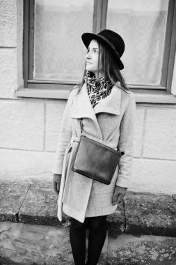 Genç kız bir gri ceket ve deri handb ile siyah şapka modeli