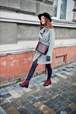 Genç kız bir gri ceket ve deri handb ile siyah şapka modeli