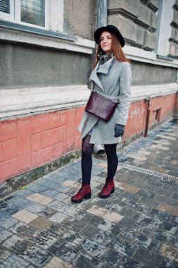 Genç kız bir gri ceket ve deri handb ile siyah şapka modeli